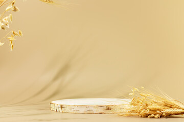 Natural wooden podium with bouquet of rye and wheat. Empty product display on beige background for...