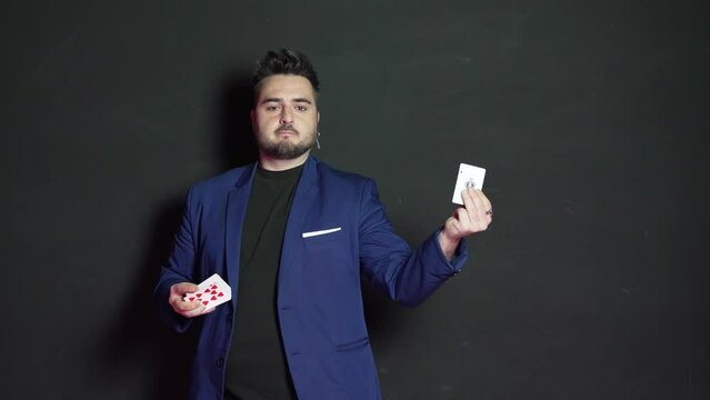 Video of a young magician in the dark who throws a card into the air from his bassara and catches it on the fly with a surprised and astonished face.
