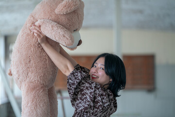 大きなクマのぬいぐるみを抱いて喜ぶ女性3