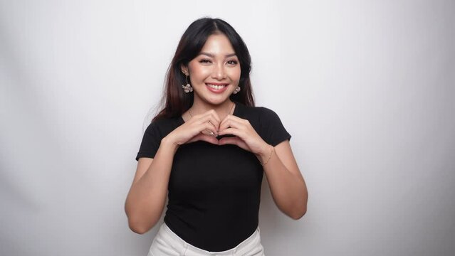 Asian beautiful smiling girl showing love sign with hand isolated white background. Indonesian Women