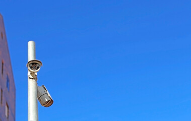Fototapeta na wymiar Security surveillance camera, monitoring system in a city on blue background