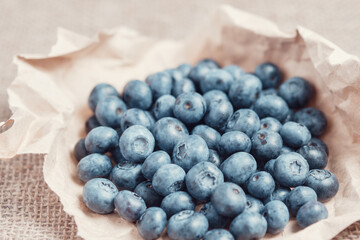 Bunch of blueberries collected in a piece of crumpled craft paper.