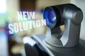 A blue beam glows from the projector inside which is the inscription - NEW SOLUTION