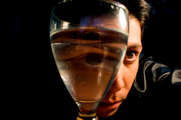 man with a glass of water deforming his face