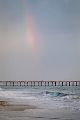 Rainbow over the pier on a stormy beach day in Oceanside