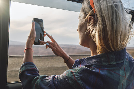 Woman taking a picture of Grand Canyon through the car window