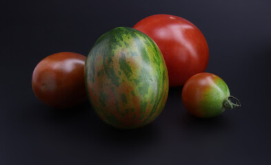 Colorful cherry tomatoes on black background