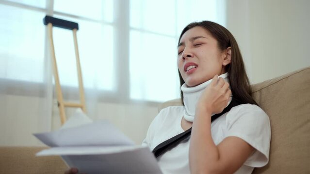 UnHappy woman stressed pay invoice medical expenses from accident fracture broken bone injury with leg splints in cast, neck splints collar, sling support arm. Social security and health insurance.