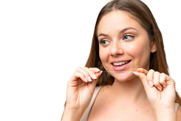 Young blonde woman over isolated chroma key background using dental floss with happy expression....