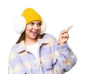 Young blonde woman wearing winter muffs over isolated chroma key background pointing finger to the side and presenting a product
