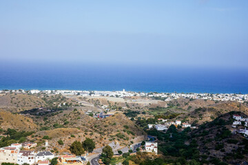 View of a white village on the horizon from the mountain with the sea in the background in the Canary Islands.