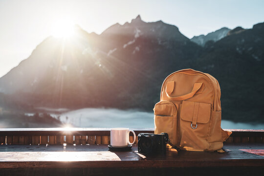 Travel backpack and camera with landscape view of mountain at sunrise