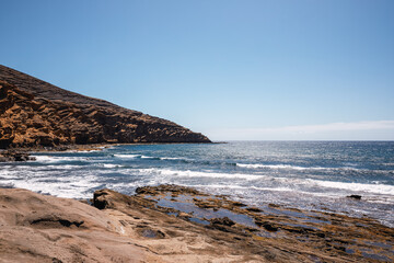 Landscape of sand and volcanic mountains by the sea in the Canary Islands