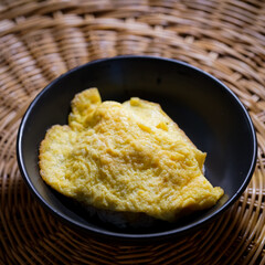 omelette rice in a black bowl