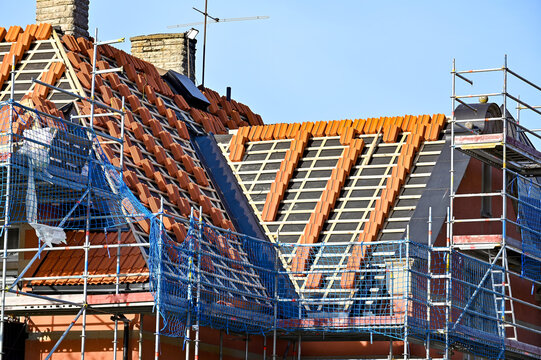 red roof tiles piled on roof renovation