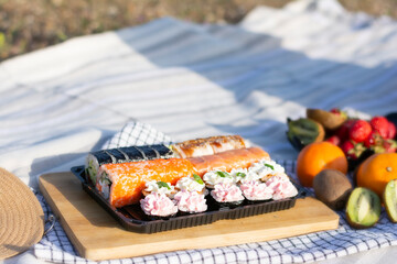 Close-up picnic in nature set of European sushi with berries at a picnic. Delicious food. Picnic in nature