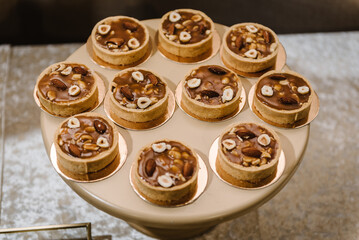 Tartlet's pastries with cream, topped with nuts. Dessert ganache chocolate tartlet. Traditional french sweet pastry tart.