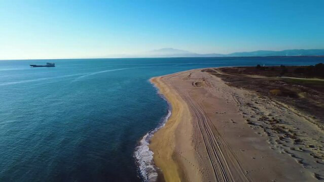 Aerial of beautiful coastline and ferry boat travelling at sea. Keramoti, Greece.