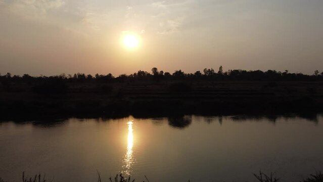 Drone Taking off. 4k. Showing Sunset on a River Bank with Bushes and Nature.