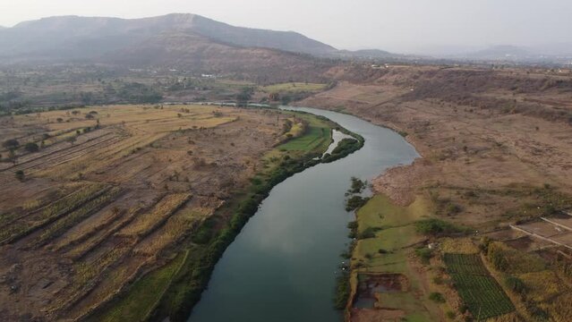 Aerial Footage and Drone 4k of a Green River Bank and a Bend in River Path with Clean Water, Hills in Tropical Region, Summer Vacation, Nature, Tropical Holidays , India, Pune, Bhor, Maharashtra