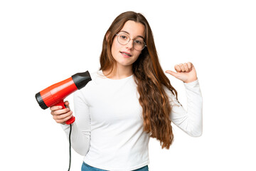 Teenager girl holding a hairdryer over isolated chroma key background proud and self-satisfied