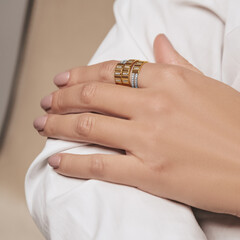 Woman Jewelery concept. Woman hands close up wearing rings, earrings and necklace modern accessories elegant life style.