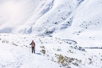 Fototapeta na wymiar snowshoe mountaineer descends path into snowy mountains