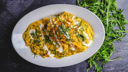 Coconut chicken curry marinade with sauce and coriander on a white plate black background.
