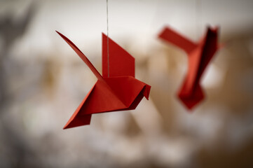 Japanese folded Origami cranes hanging on with strings. Hundreds handmade paper birds isolated with copy space. 1000 thousand crane sculpture topic. Symbol of peace, faith, health, wishes, hope