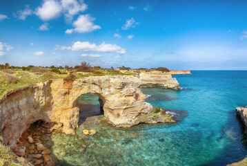 Fototapeta na wymiar Stunning seascape with cliffs rocky arch and stacks (faraglioni) at Torre Sant Andrea