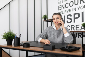 Naklejka premium Business woman European appearance with a short haircut speaks on the phone in the office
