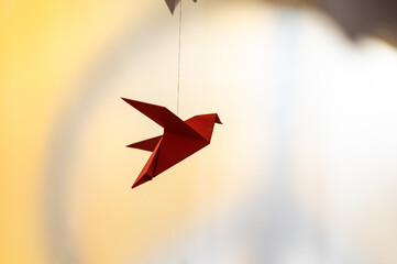 Japanese folded Origami cranes hanging on with strings. Hundreds handmade paper birds isolated with copy space. 1000 thousand crane sculpture topic. Symbol of peace, faith, health, wishes, hope