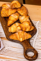 Croissant. Bakery. Wooden board with stacked croissants.