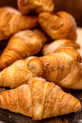 Croissant. Bakery. Close-up detail of croissant stacked on wooden board.