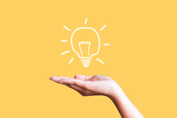 woman holding icon light bulb on yellow background,idea concept