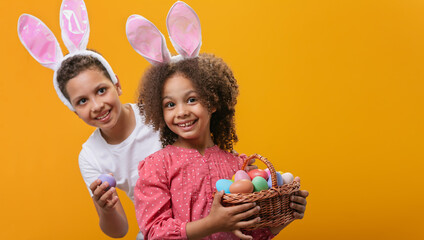 Fototapeta na wymiar A children with rabbit ears on her head with a basket full of Easter eggs