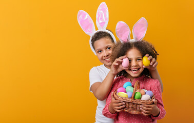A happy children with rabbit ears on her head with a basket full of Easter eggs