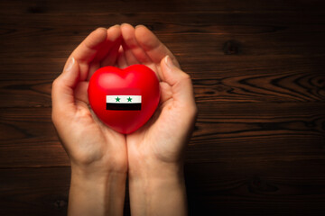 female hands hold and giving red heart in the form of a Syria flag, support concept