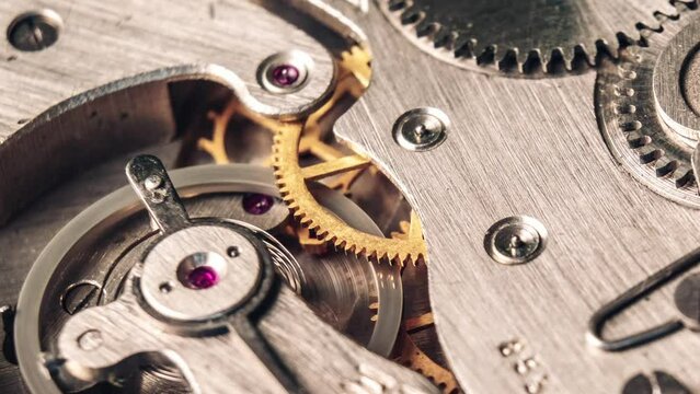 Timelapse of mechanism of vintage stopwatch with rotation close-up. Round clock watch mechanism working, macro. Old retro clockwork gears, cogwheels, and pendulum movement inside the ancient clock. 4K