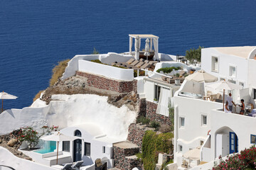 Whitewashed houses with terraces and pools and a beautiful view in Oia on Santorini island, Greece
