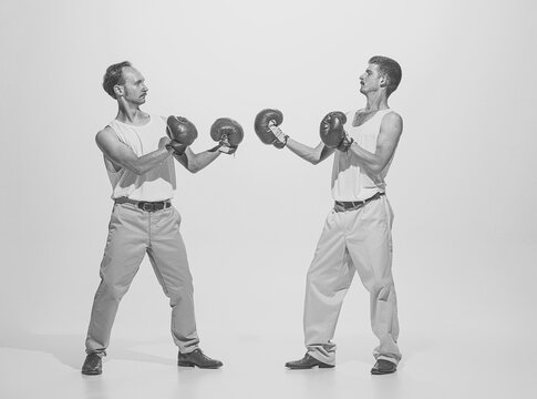 Vintage portrait of two retro men boxing in gloves. Funny image of two friends. Sport, retro fashion style art photography
