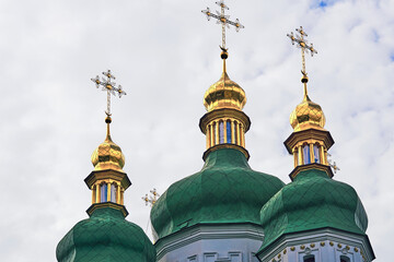 Fototapeta na wymiar Golden domes with dark green roof of the Vydubychi Orthodox Monastery in Kiev