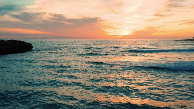 splendido tramonto sul mare in inverno, con le onde che si infrangono sulla spiaggia, marina di pulsano, salento, puglia, taranto , italia