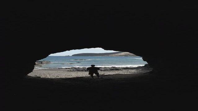 Porto Santo Island - Vertical drone shot from behind a tourist on a rocky tunnel near porto dos frades and gruta da dona beija