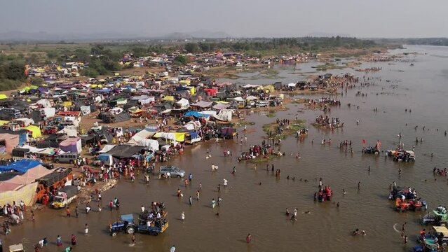 A huge crowd of people camped at the riverbank during a Hindu religious festival