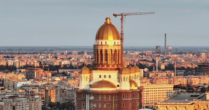 People's Salvation Cathedral, National Cathedral in Bucharest, Romania turn aerial view history Center at dawn in summer against blue sky lens flares zoom. Travel. Tourism