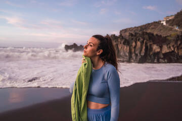 woman wiping her sweat after training on the beach.