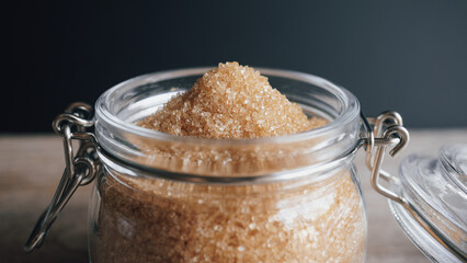 Natural cane sugar in glass jar on wooden table - 571209299