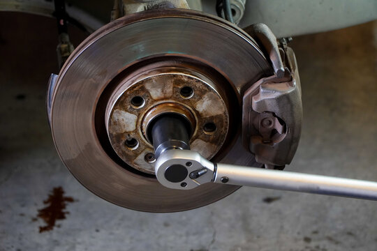 mechanic uses a pound wrench to tighten the car brake disc.car brake disc assembly