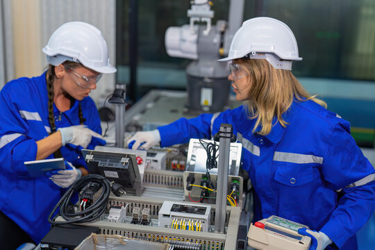 Female Electronics Factory Workers use tablet pc quality checking Circuit Boards after assembly - Powered by Adobe